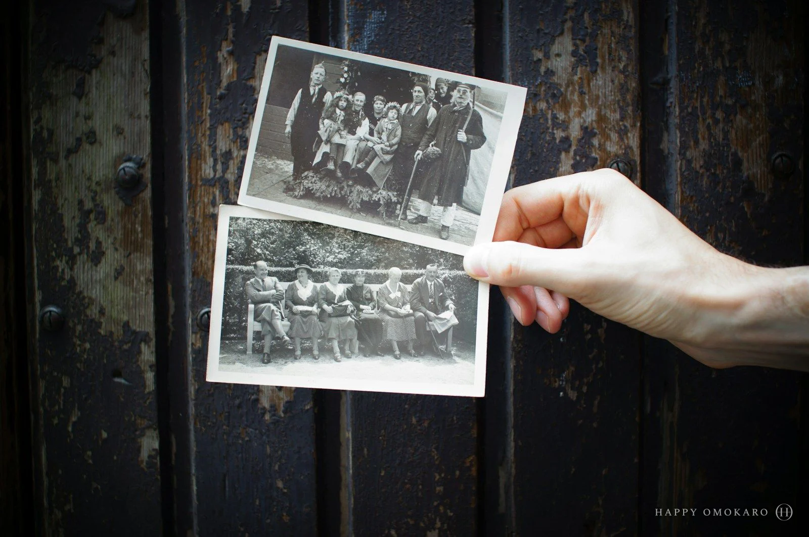 A person holding a fan of small vintage photographs