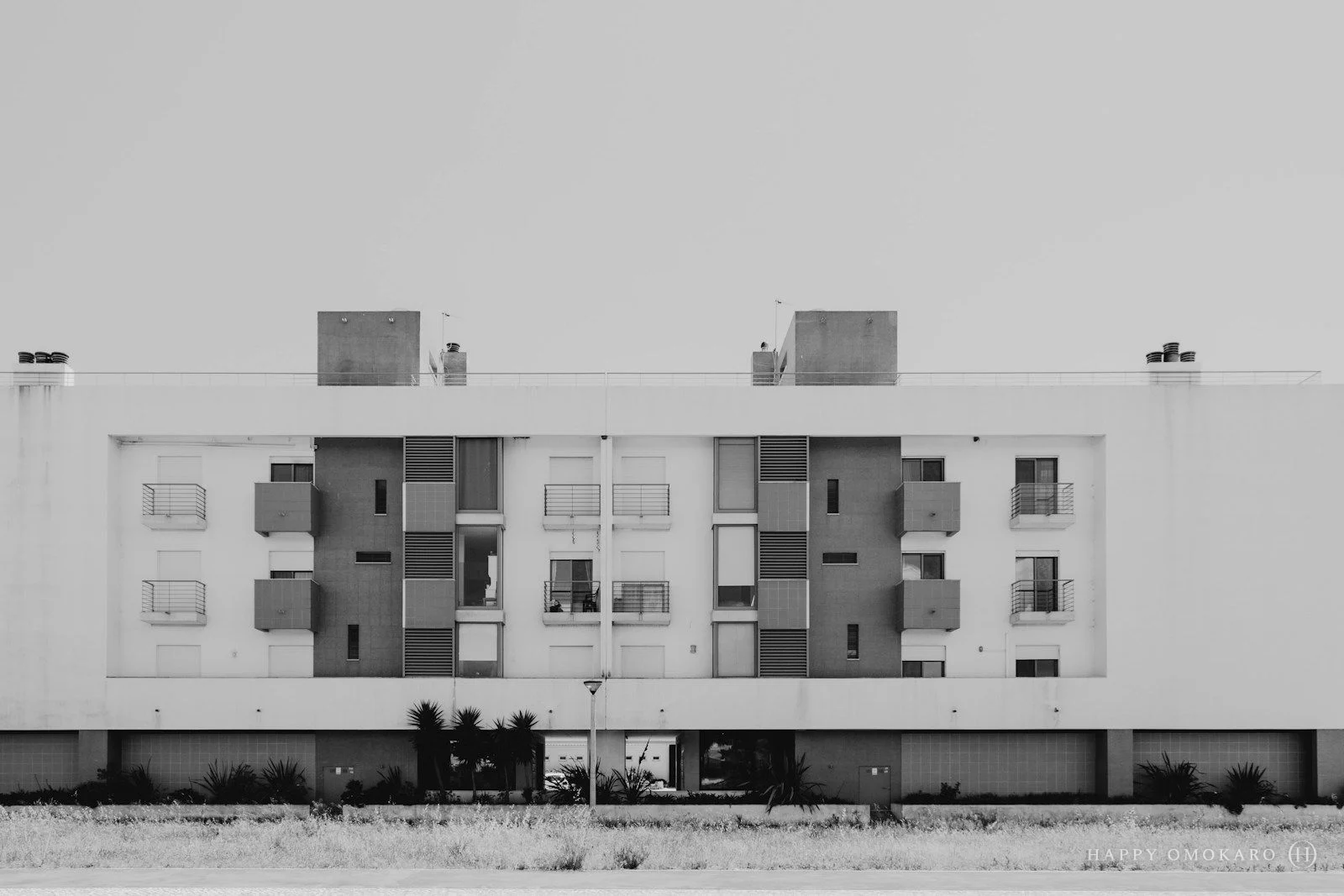 A grayscale photograph of a concrete building under a pale sky