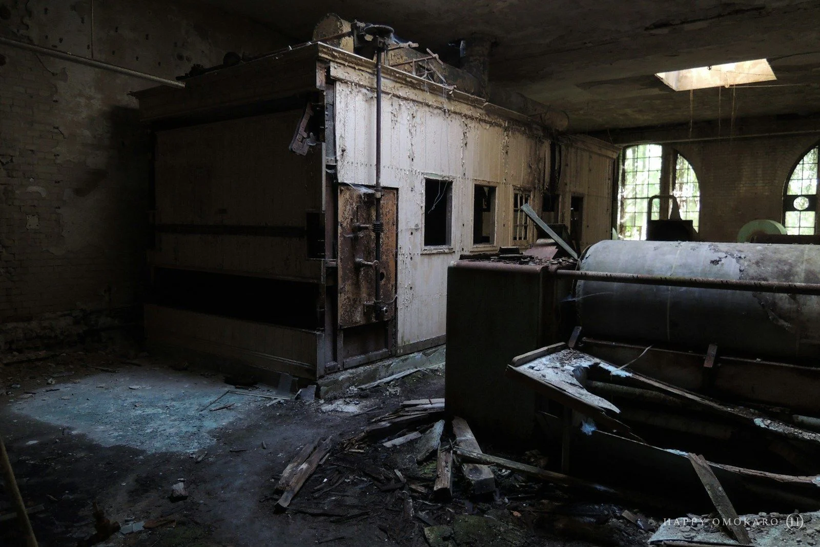 A dark building interior with a shaft of light reaching across to a far wall