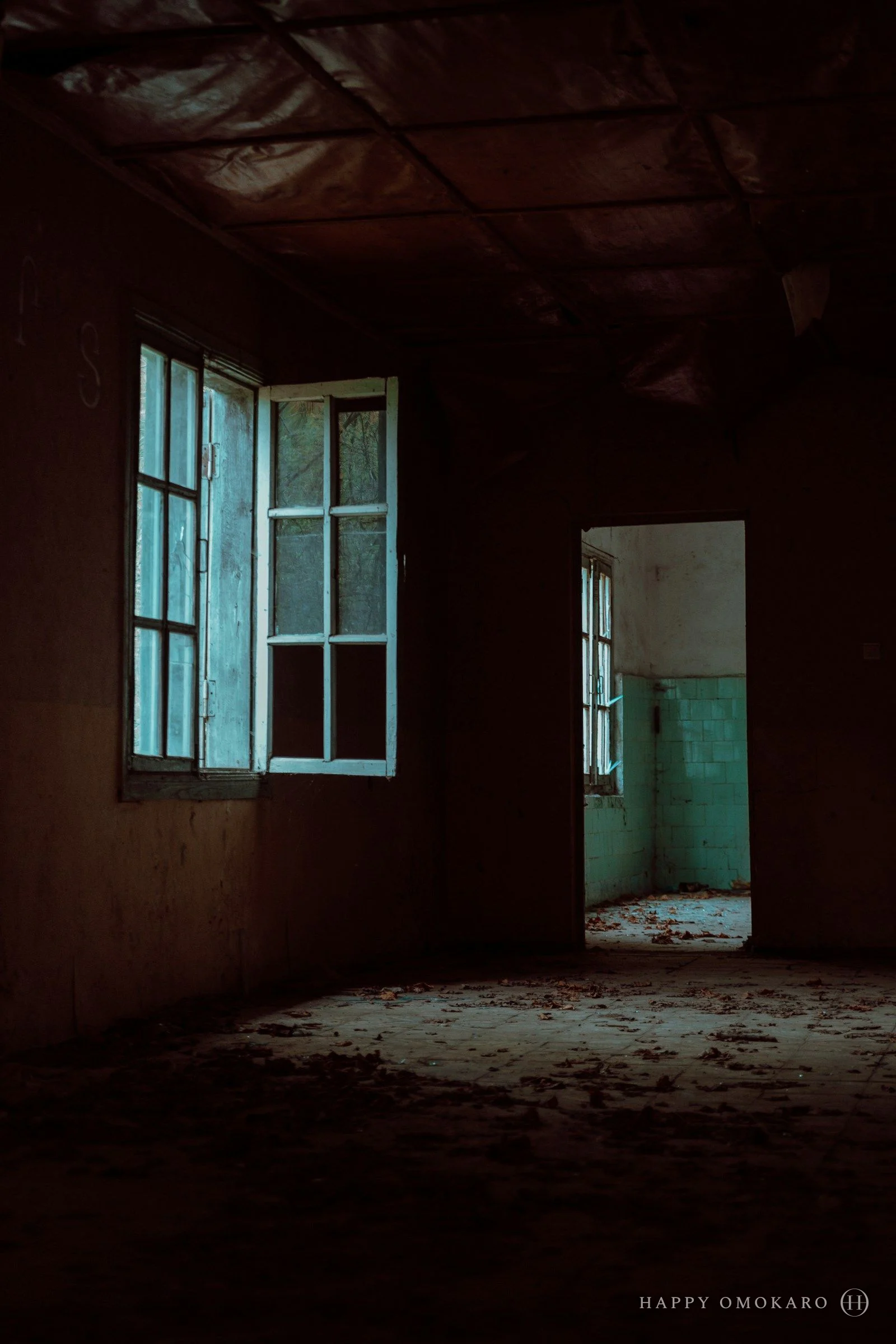 A dim interior corridor turning towards a lit doorway