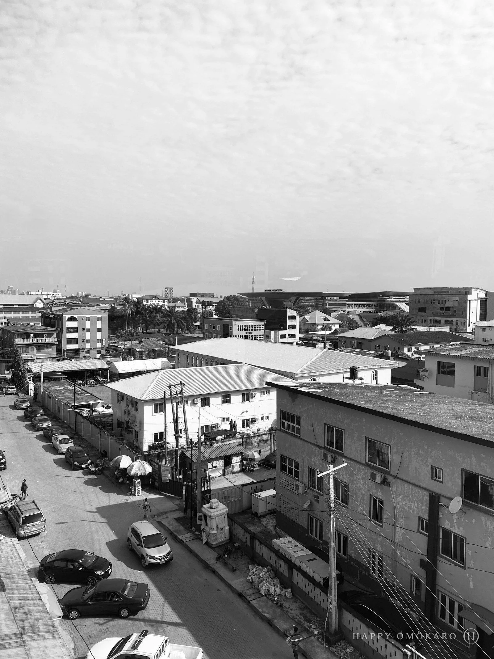 A black and white photograph of a city street stretching into the distance
