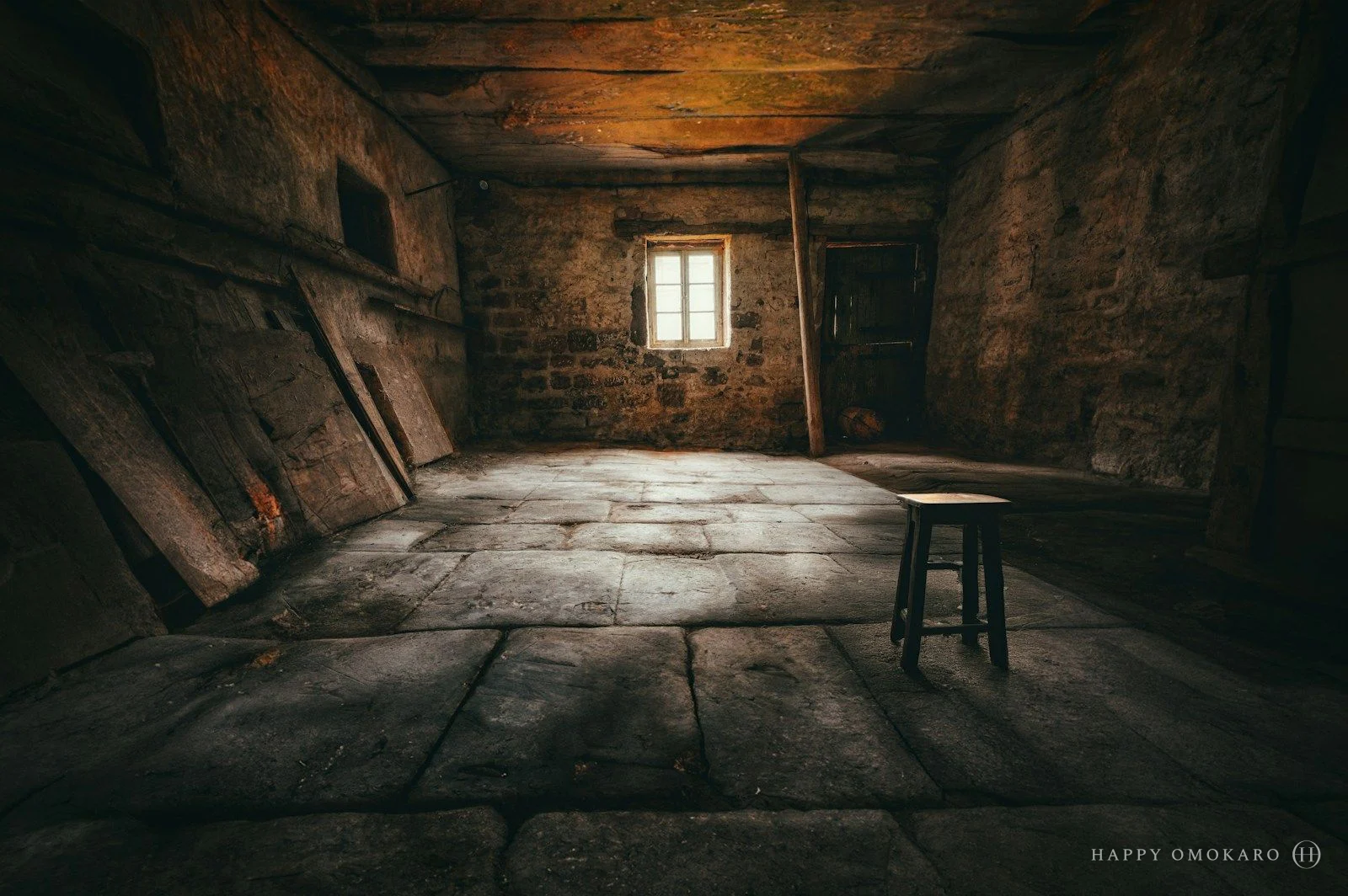 A single stool beneath an attic window, the light resting on the floorboards